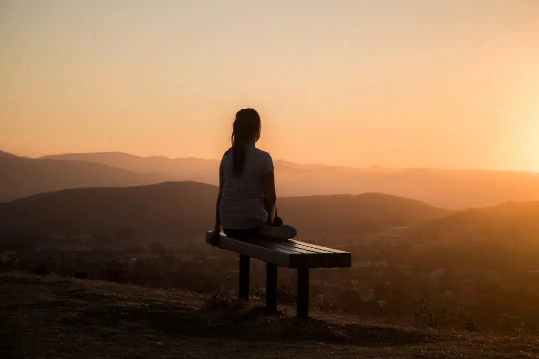 Person sitting peacefully in nature practicing mindfulness for mental health